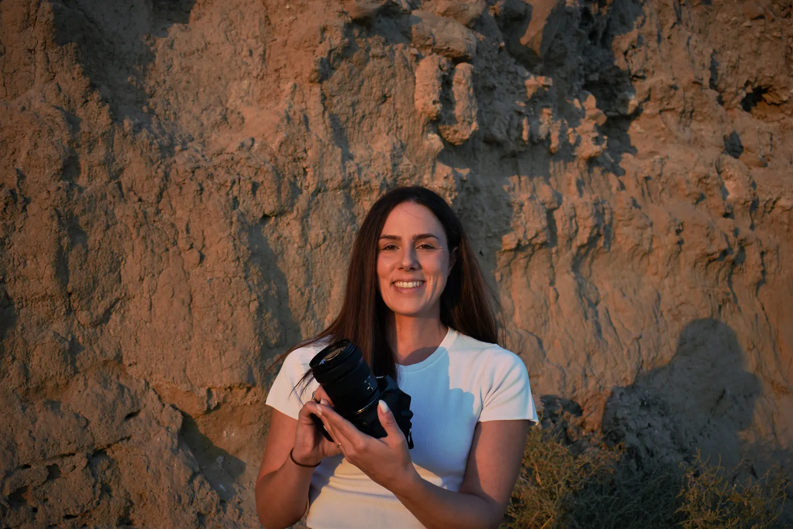 Avgi Chourlia holding her camera against a sunlit rock face